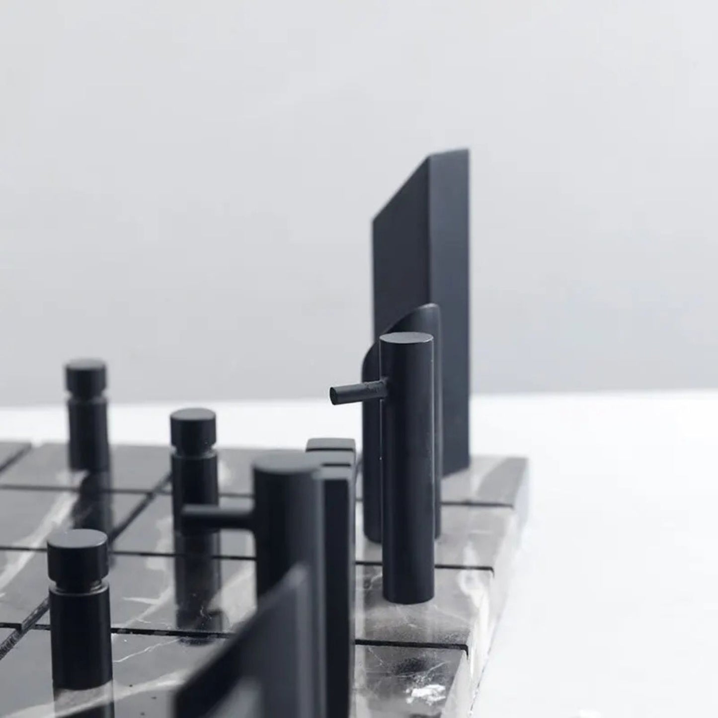 Tablero de Ajedrez de Mármol con Piezas Metálicas Doradas y Diseño Geométric